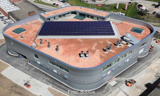 Luftaufnahme von neuem Fabrikgebäude mit einer PVT-Anlage auf dem Dach.