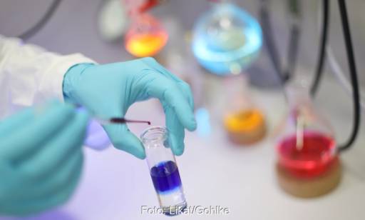 Im Bild eine Hand mit Handschuh im Chemielabor als Symbol für den Wasserstoff Speicher Backpulver.