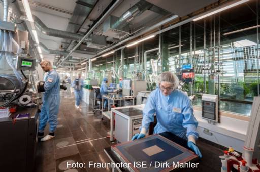 Personen in Reinraumanzügen im Labor bei der Prüfung von Solarzellen