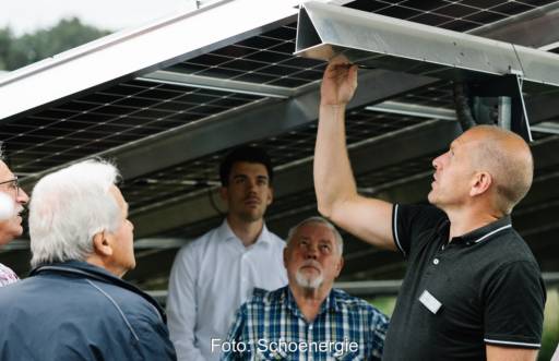 Im Bild Menschen zwischen Photovoltaik-Modulen bei der Eröffnung vom Photovoltaik-Solarpark Minderlittgen.