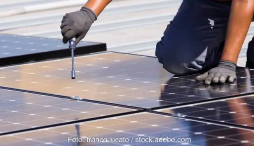 Im Bild ein Mensch, der ein Photovoltaik-Modul festschraubt, 100 GW Solarleistung in Deutschland sind bei Ende 2024 möglich.