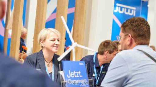 Im Bild zwei Menschen im Gespräche auf einer Messe, Juwi ist auf der Windenergy in Hamburg vertreten.
