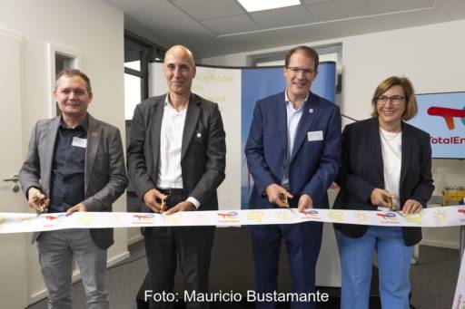 Drei Männer und eine Frau schneiden ein Band durch, auf dem Total Energies steht - Eröffnung des neuen Büros in Hamburg.