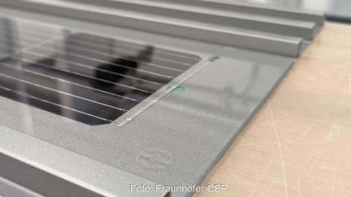 auf einem Tisch liegendes Profil für eine Aluminium-Fassade mit Solarzelle darauf.
