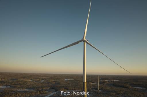 Foto von Windturbine mit Hybridturm von Nordex - man erkennt den unteren Teil des Turms aus Beton in grau, den oberen aus Stahl in weiß.