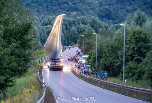 Transport eines Rotorblattes für Windturbine über eine Landstrasse mit Schaulustigen.