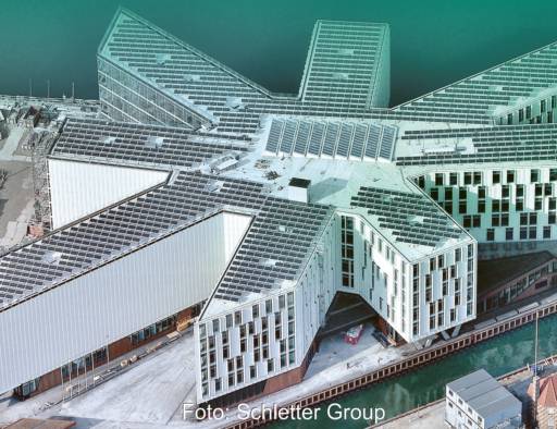 Im Bild ein Gebäudekomplex, das mit einer Photovoltaik-Anlage bestückt ist, die ein Montagesysteme vom Solarmontage-Hersteller Schletter nutzt.