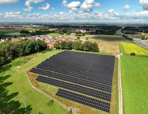 Luftbild einer Freiflächensolaranlage im grünen Umfeld.