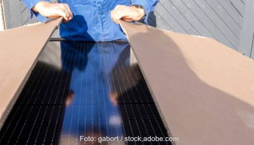 Im Bild ein Mann der einen Karton mit Photovoltaik-Modulen öffnet. Ab 2 kW soll eine Smart Meter Pflicht gelten.