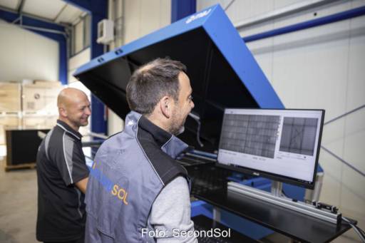 Zwei Männer vor Prüfappartur mit Bildschirm im Lager.