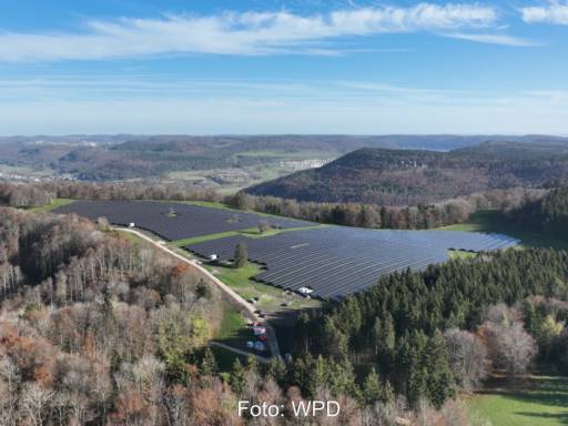 Luftbild eines PV-Parks von Hügeln umgeben.