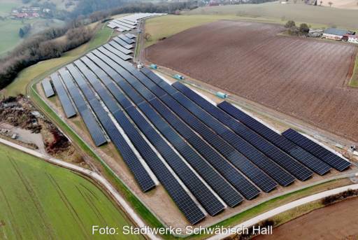 Luftbild zeigt PV-Freifläche von Wiesen und Äckern umgeben.