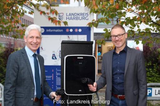 Zwei Männer des Landkreises Harburg mit Ladekabeln für E-Autos.
