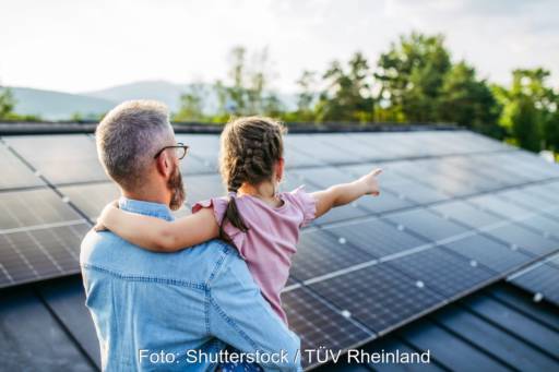 Mann mit Kind auf dem Arm auf einem Dach