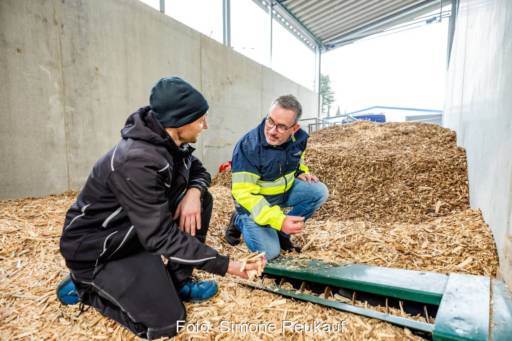 Zwei Männer in einem Hackschnitzellager.