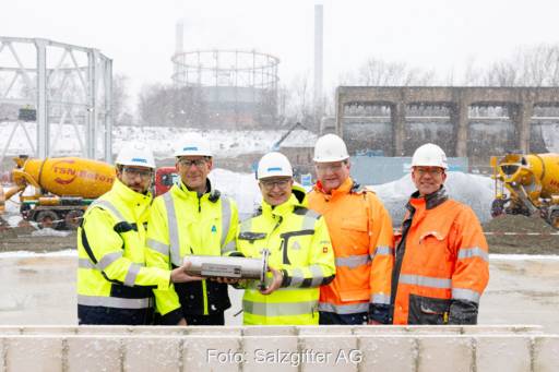 Drei Männer in Signaljacken bei der Grundsteinlegung.
