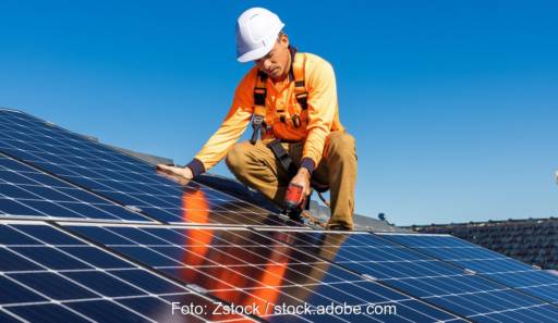 Ein Mann installiert eine Photovoltaik-Anlage, der Abgrenzungsleitfaden greift zu kurz, wenn er nur die Dachinstallation im Blick hat.