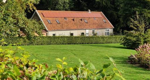 Ein älteres Gebäude, das farbige Photovoltaik-Module von Soluxa auf dem Dach trägt.