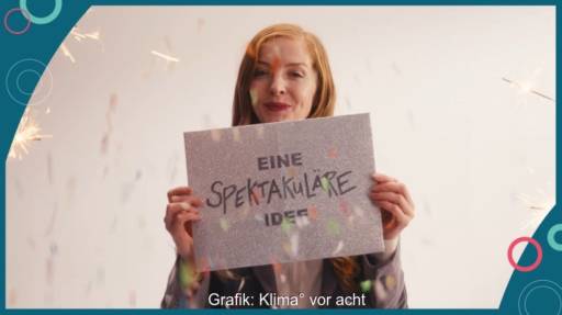 Im Bild eine Frau mit einem Schild „eine spektakuläre Idee“, die für Klima° vor acht wirbt.
