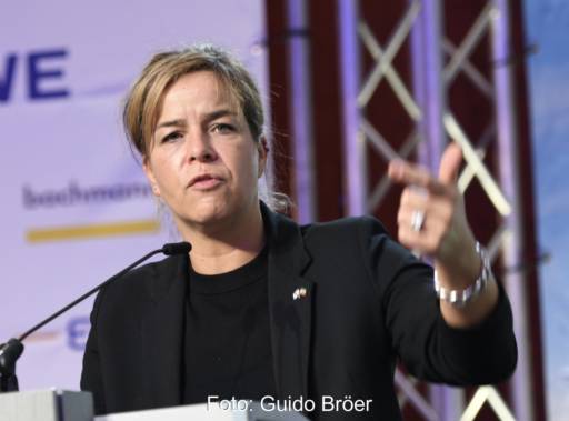 Eine Frau mit schwarzer Kleidung hinter einem Rednerpult - Mona Neubaur bei Eröffnung der Windenergie-Tage