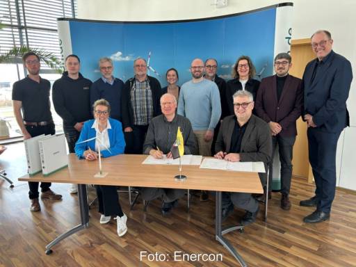 Vertragsunterzeichnung zur Windkraft in einem Saal mit zwölf anwesenden Personen.