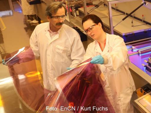 Im Bild sind zwei Wissenschaftler:innen, die Solarzellen aus dem Drucker in den Händen halten, die für Multi-Benefit-PV geeignet sind.