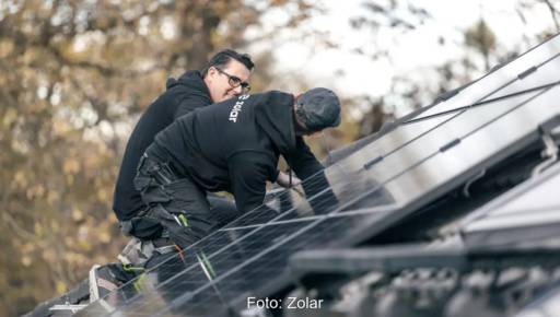 Im Bild zwei Männer, die eine Photovoltaik-Anlage installieren, Zolar hat Strategiewechsel vorgenommen.