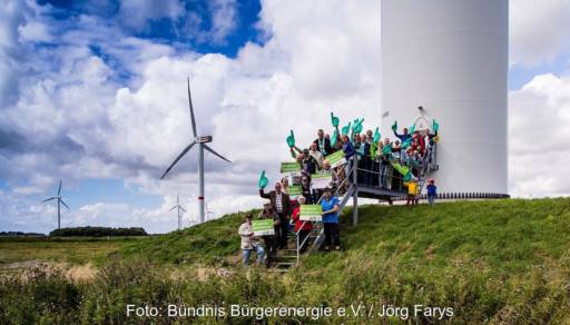 Menschen vor Windenergieanlage, der Michael-Sladek-Preis für Bürgerenergie wird erstmals ausgelobt.