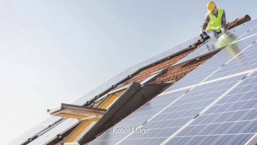 Ein Handwerker installiert eine Photovoltiak-Anlage von Mage Autark.