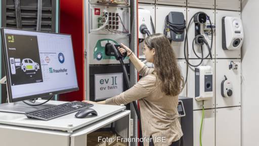 Mitarbeiterin von Forschungsinstitut prüft Ladevorgänge im Laborumfeld.