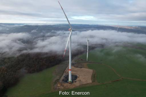 Mehrere Windturbinen im wolkigen deutschen Mittelgebirge.
