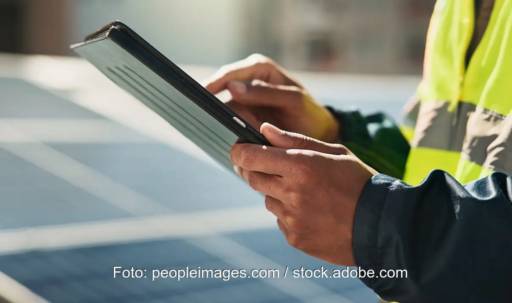 Im Bild ein Mann mit Tablett, Qcells setzt die Photovoltaik-Planungssoftware von Aurora Solar ein.