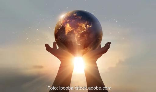 Zwei Hände halten einen Globus in die Sonnen als Symbol für den Erdüberlastungstag.