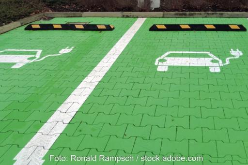 Grün eingefärbte Parkplatzflächen mit einem Symbol für Elektrofahrzeuge.