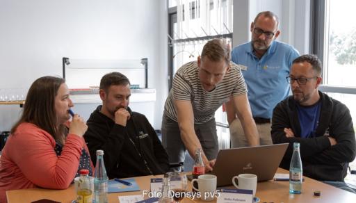 Menschen an einem Bildschirm testen Densys Connect, eine Plattform für die Photovoltaik-Projektabwicklung.