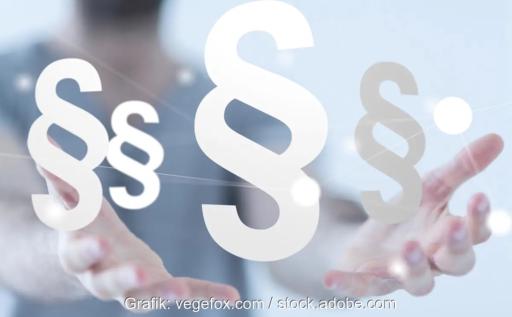 Im Bild zwei Hände mit mehreren Paragrafen als Symbol für das geplante Heizungsgesetz.