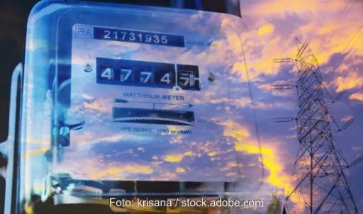 ein Himmel im Morgenrot mit Wolken spiegelt sich in Scheibe vor Stromzähler - Symbolbild für Smart Meter Rollout