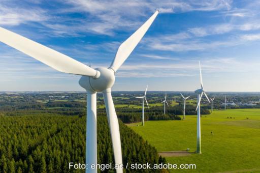 Windpark im Flachland, das Äcker, Wälder und Ortschaften aufweist.