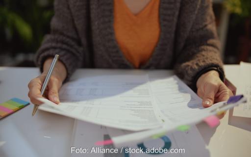 Im Bild eine Person an einem Tisch mit Papieren, die rückwirkende Abmeldung von Stromverträgen ist nicht mehr möglich.