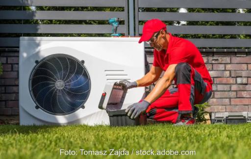 Im Bild ein Monteur mit Wärmepumpe, die Regulierung der Wärmewende ist umstritten.