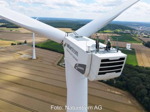 Zwei Mitarbeiter auf einer Gondel einer Naturstrom-Windanlage.