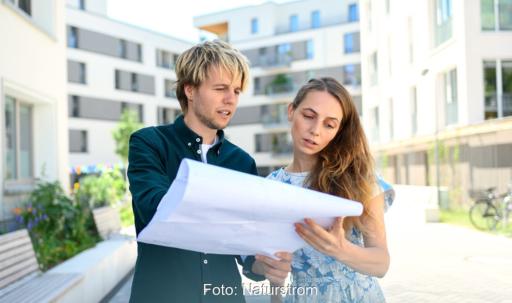 Zwei Menschen mit Plan als Symbol für die kommunale Wärmeplanung, die Naturstrom mit der Übernahme von Energyeffizienz verstärkt.