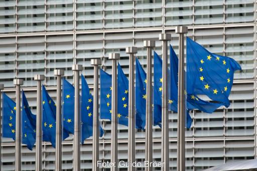 Reihe von wehenden Europaflaggen vor dem Hauptgebäude der EU-Kommission in Brüssel.