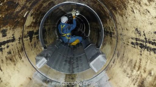 Arbeiter hockt in einem Kanalrohr und montiert einen Wärmetauscher, Initiative Abwasserwärme NRW will Abwassernutzung voranbringen.