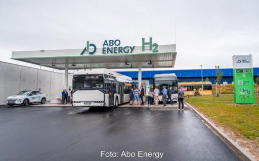 Busse tanken Wasserstoff an einer Tankstelle mit Besuchern.