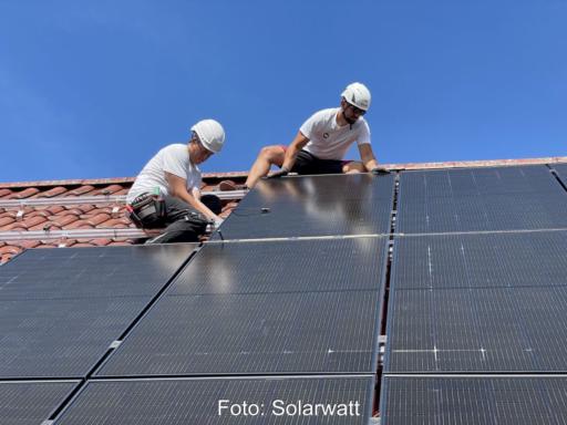 Zwei Monteure von PV-Modulen auf einem Einfamilien-Schrägdach.