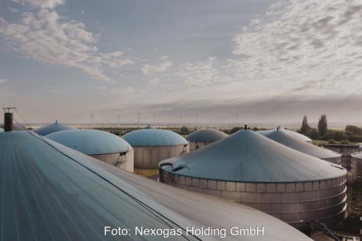 Eine Biogasanlage vor einem milchigen Horizont von schräg oben.