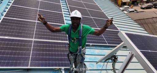 Im Bild ein People of Color, der eine Photovoltaik-Anlage installiert als Symbol für Photovoltaik Impact Investments in Afrika.