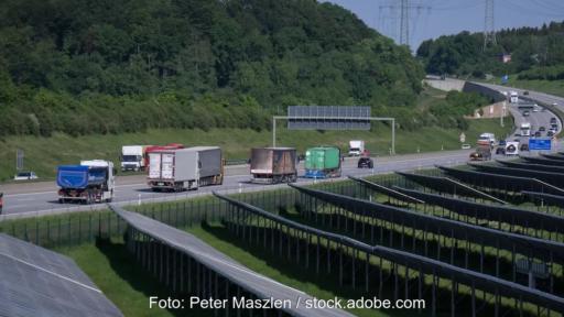 Autobahn hinter Solarpark, die Umsetzung der Erneuerbare-Energien-Richtlinie (RED III) in Deutschland soll dem Verkehrssektor Impulse verleihen.
