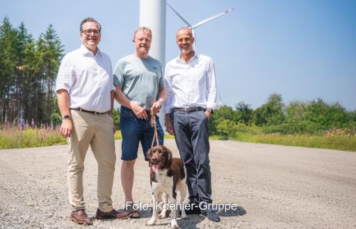 Im Bild Firmenvertreter von KB Renewables und Koehler vor Windenergie-Anlagen.